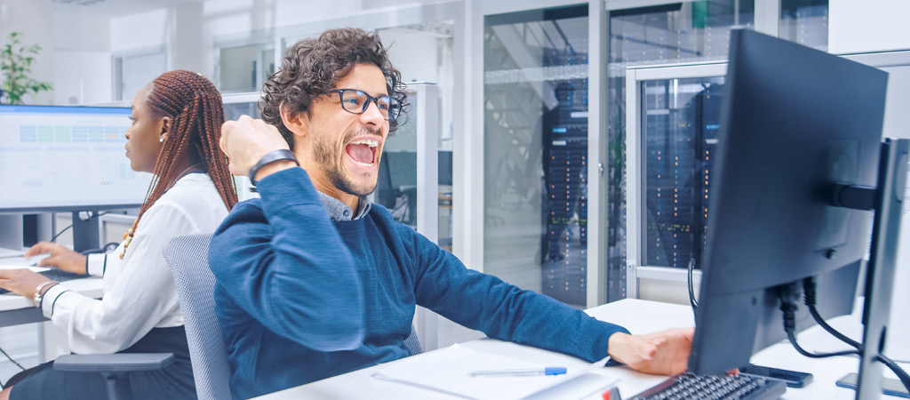 Mann am Computer freut sich