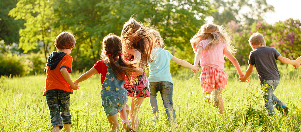 Kinder rennen über eine grüne Wiese