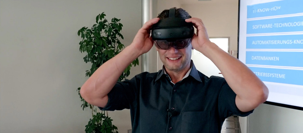 Mann mit Datenbrille auf dem Kopf lächelnd