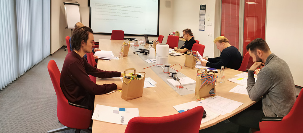 Neue Mitarbeiter sitzen an einem Konferenztisch