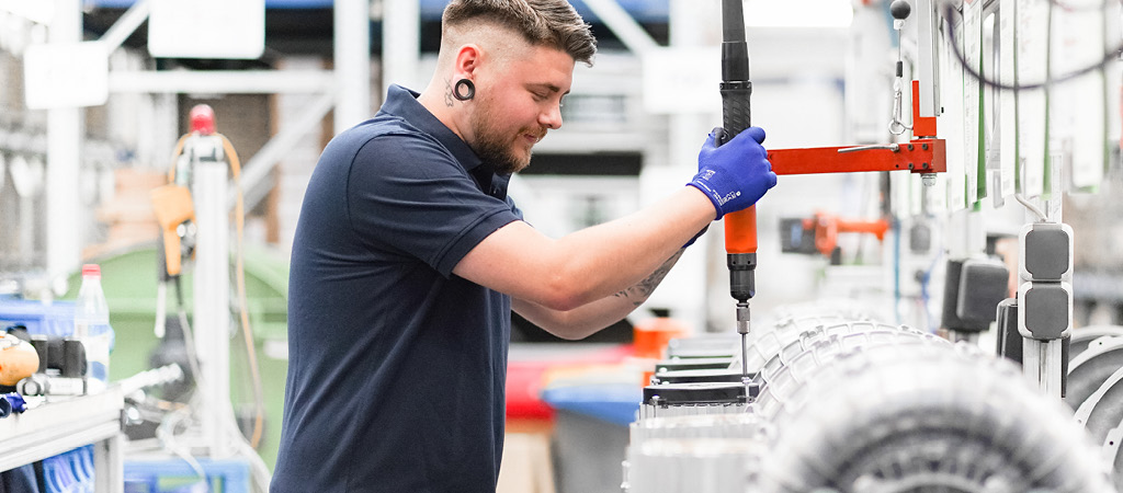 Mann bedient eine CNC-Maschine