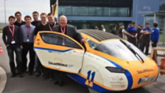 a group of people standing by a car with the door open